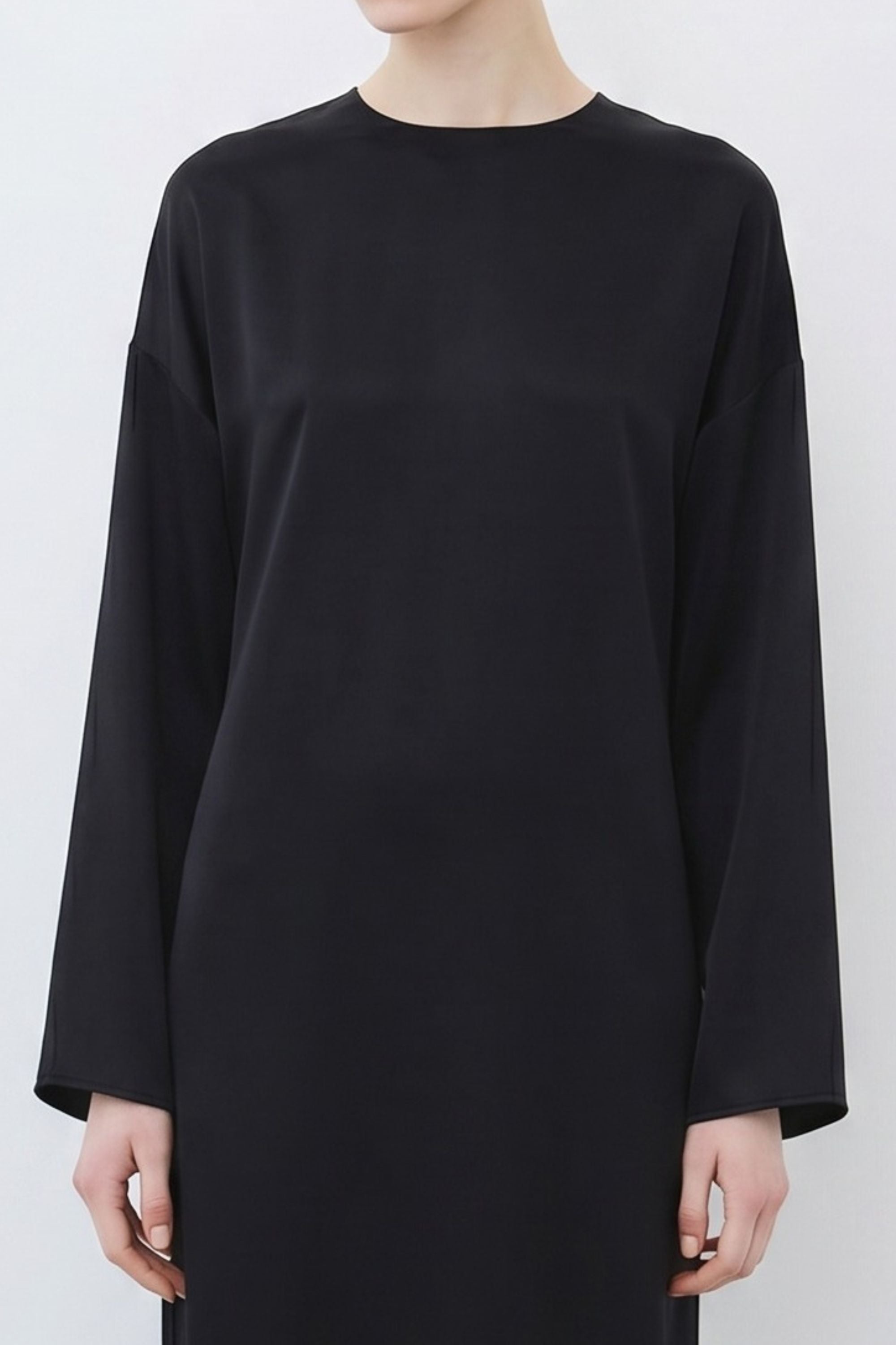 Close-up of organic silk long sleeve dress in black, showcasing round neckline and fluid texture, made in Italy by HERTH