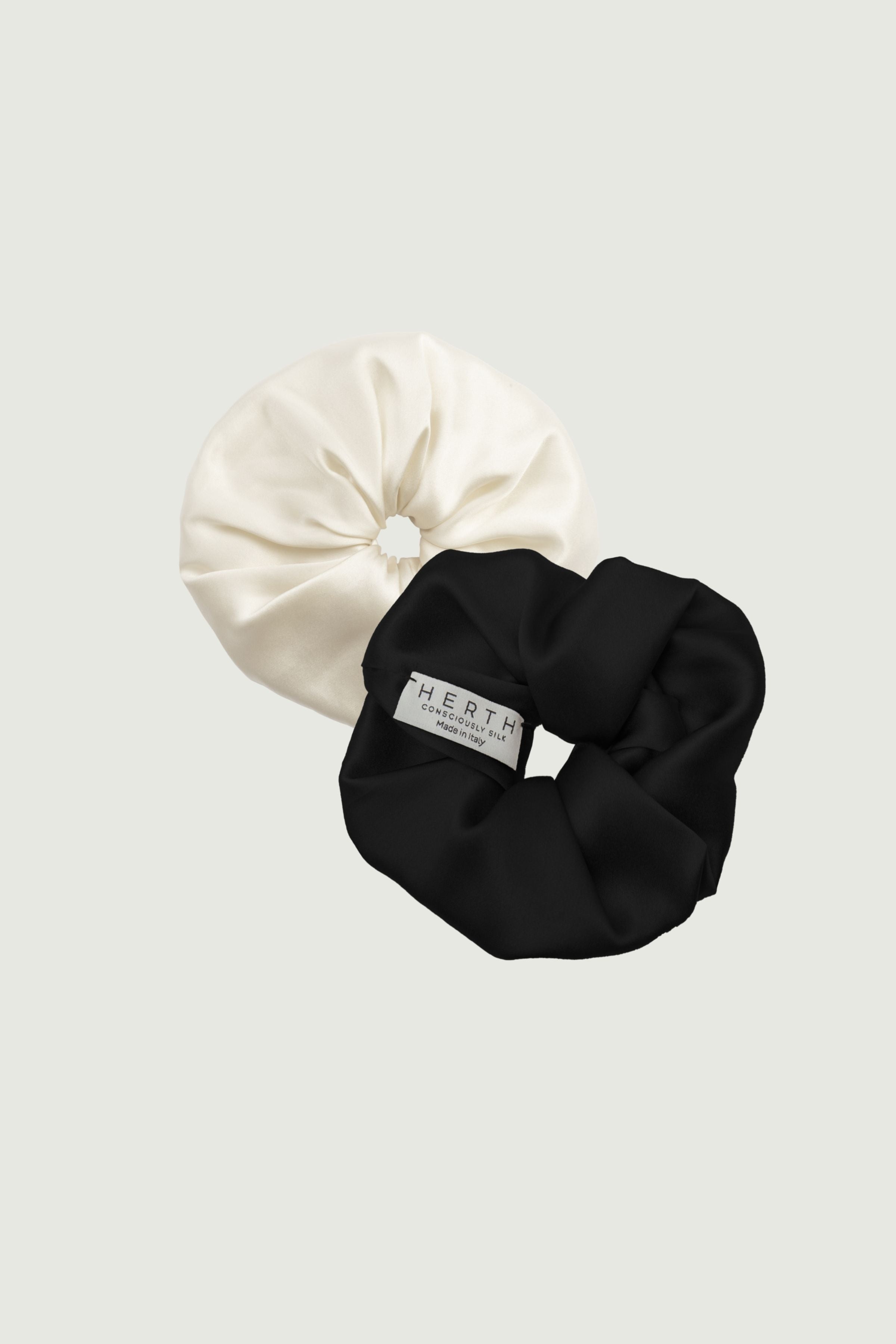 Silk scrunchies set in almond and black, two hair ties placed side by side