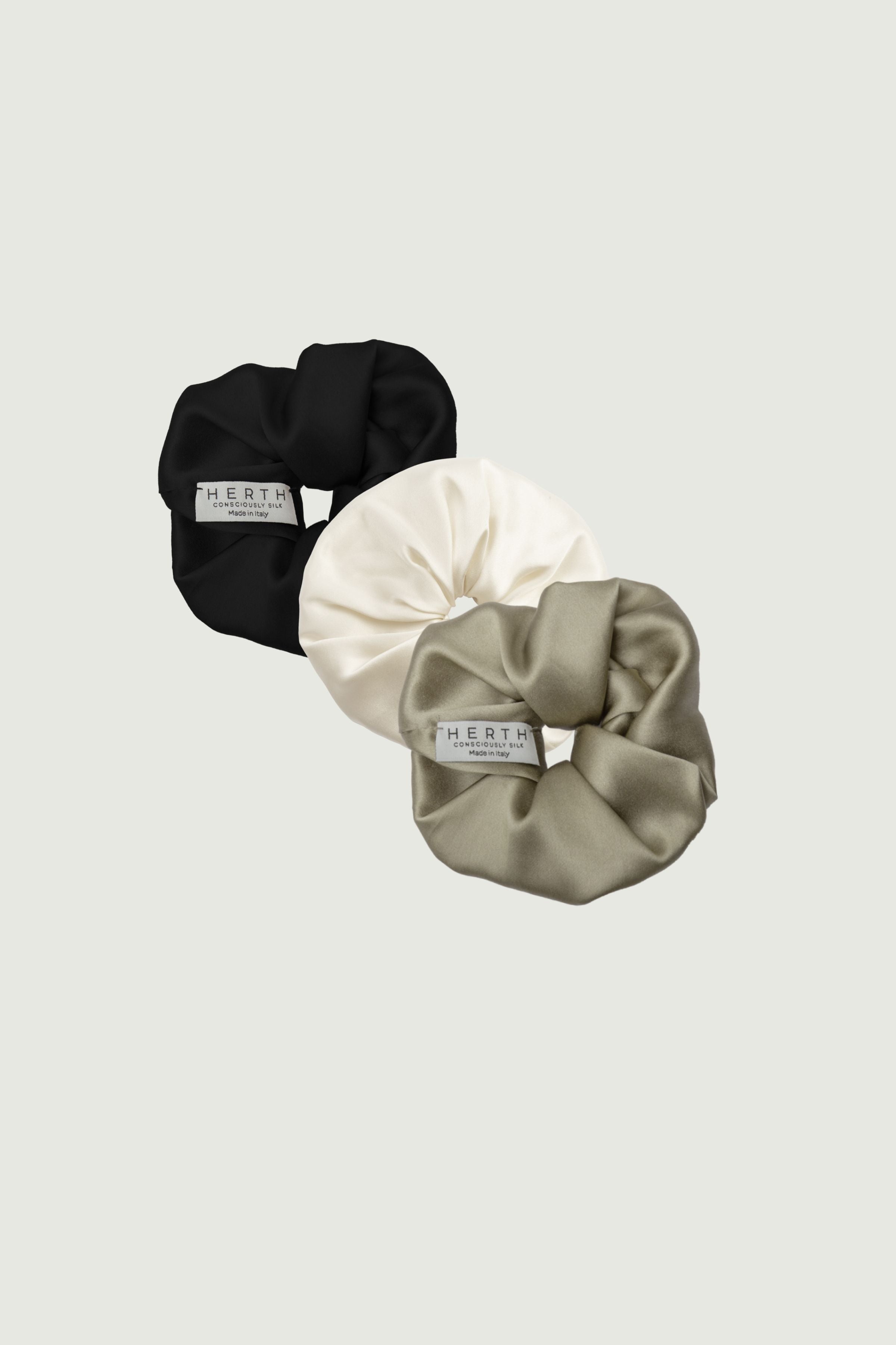 Silk scrunchies set in black, gold sand and almond, three hair ties arranged together