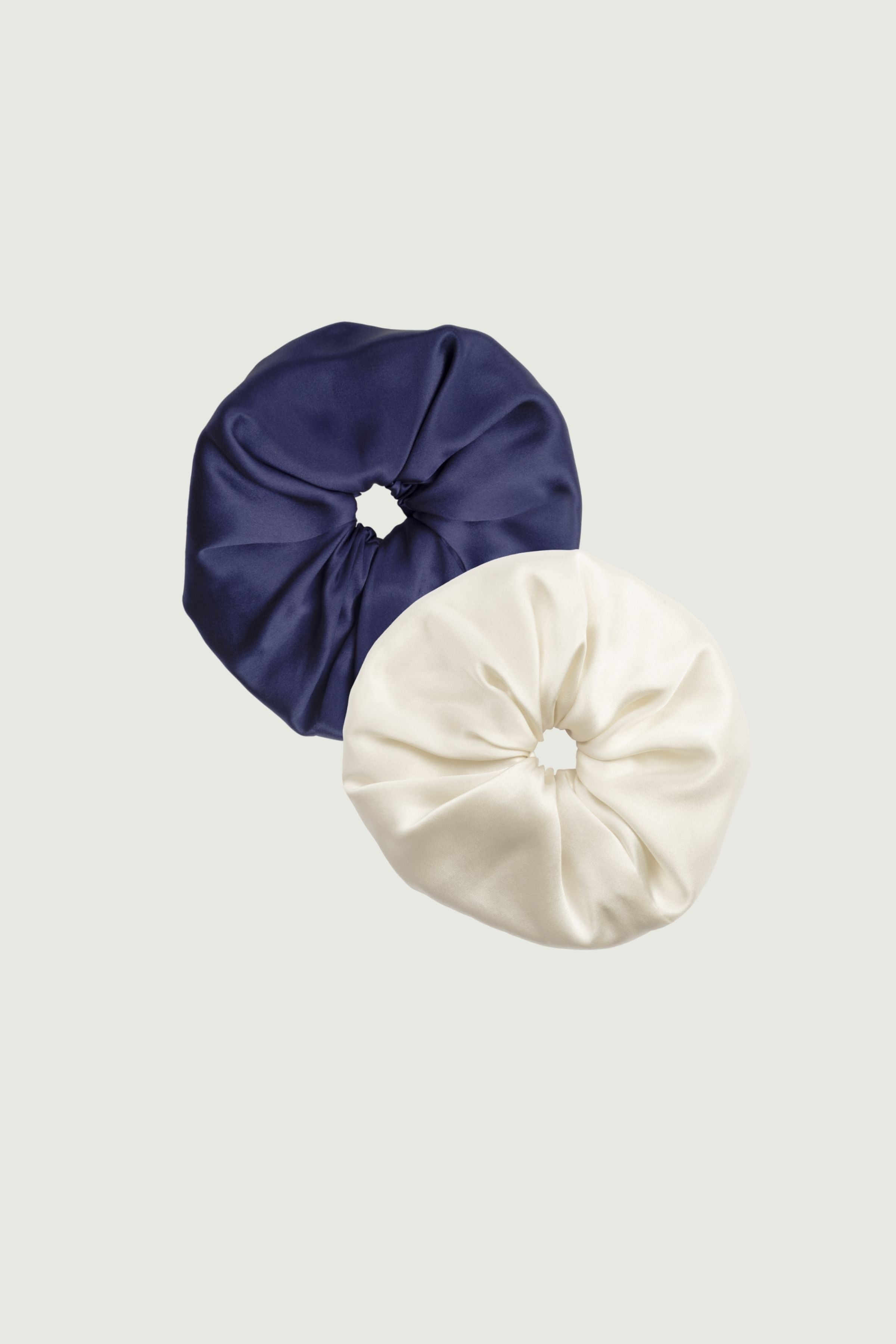 Silk scrunchies set in navy blue and almond, two hair ties placed next to each other