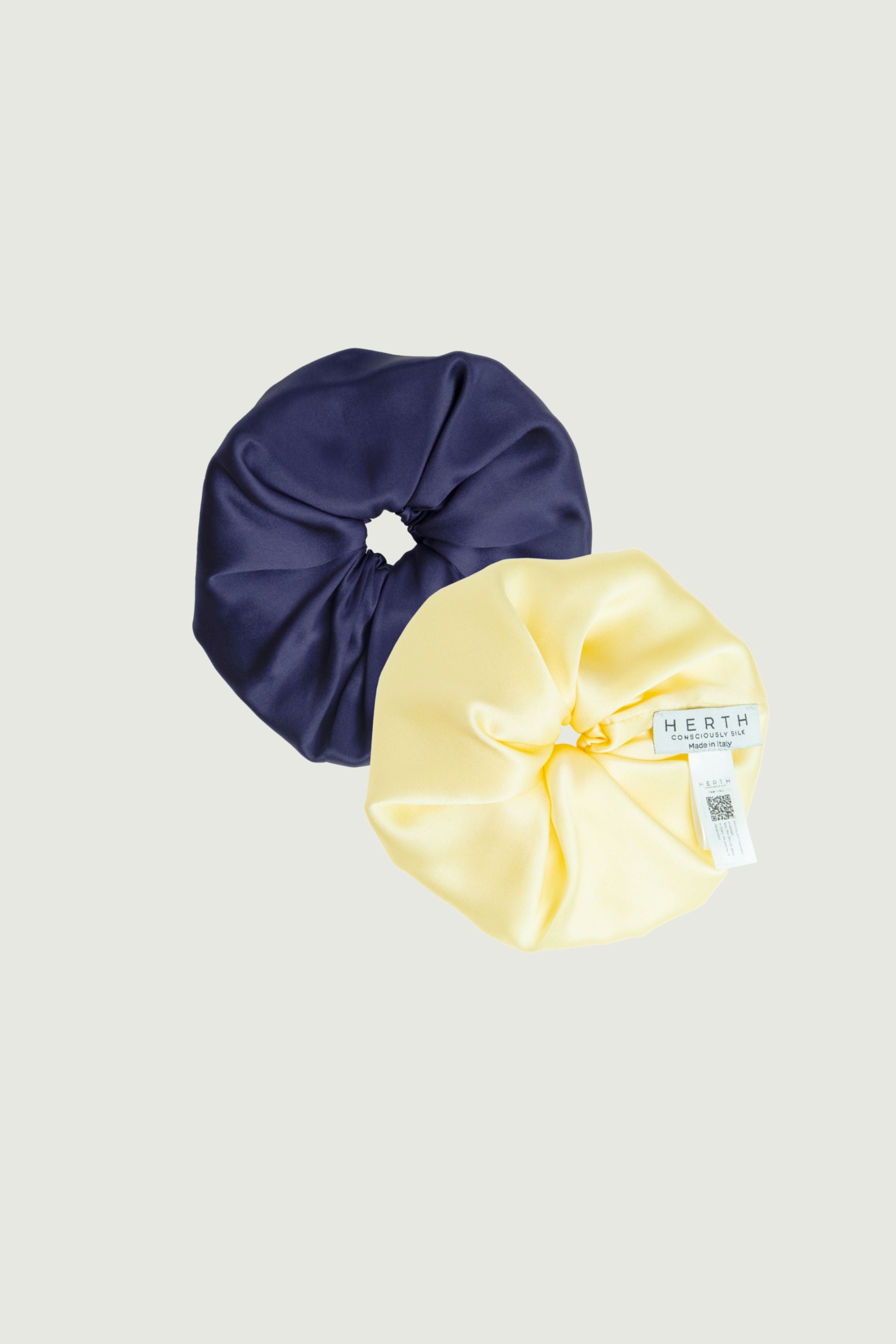 Silk scrunchies set in navy blue and butter yellow, two hair ties shown side by side