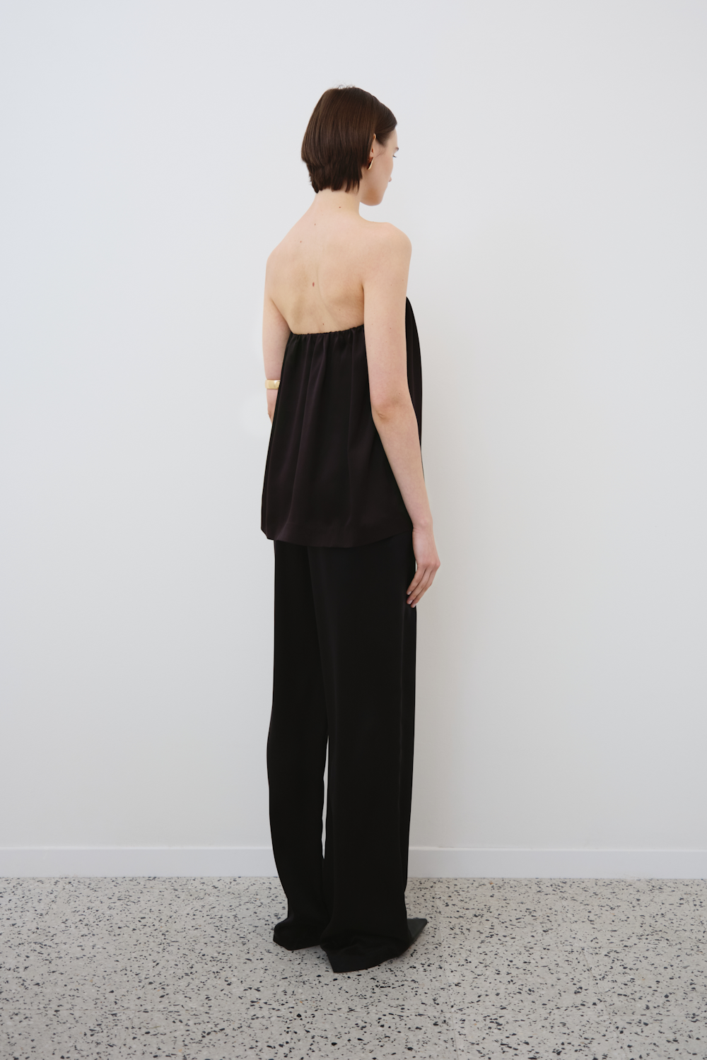 Back view of HERTH Gala silk strapless top and Joy pants in black organic silk — elegant womenswear set, sustainable and timeless fashion.