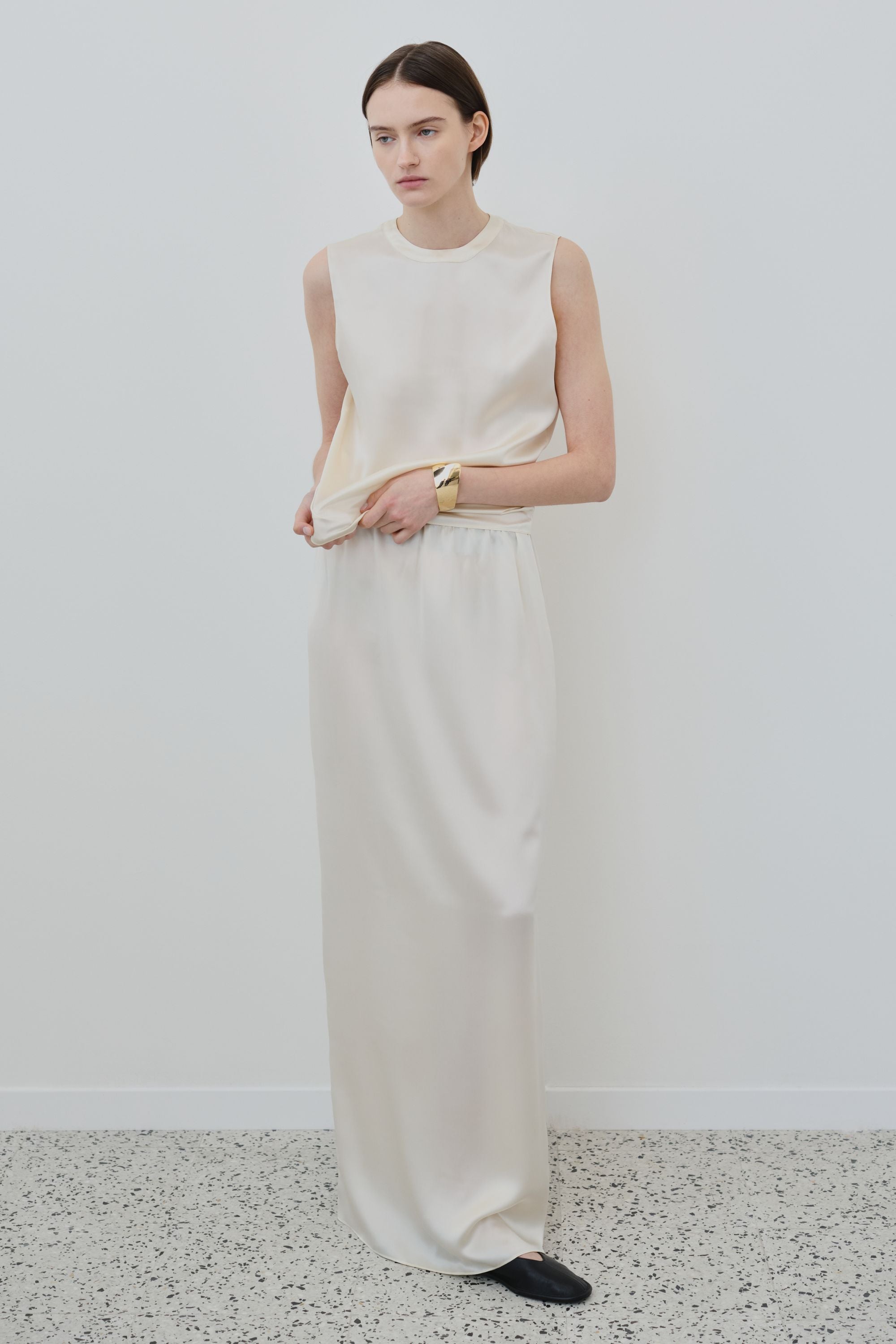 Model wearing the Nilde organic silk maxi skirt in Almond with a matching sleeveless silk top.