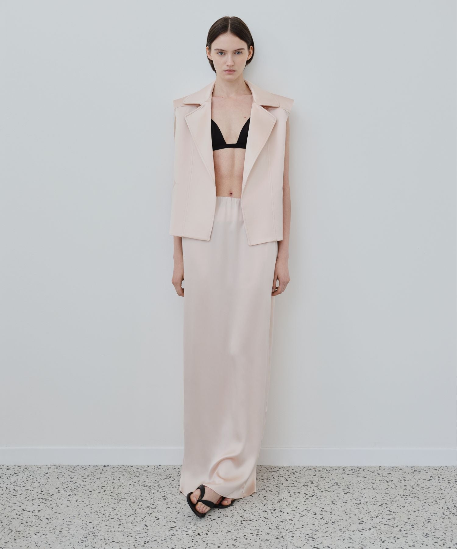 Organic silk lingerie layered under tailored vest with black bra and silk skirt, styled as a modern versatile look, HERTH