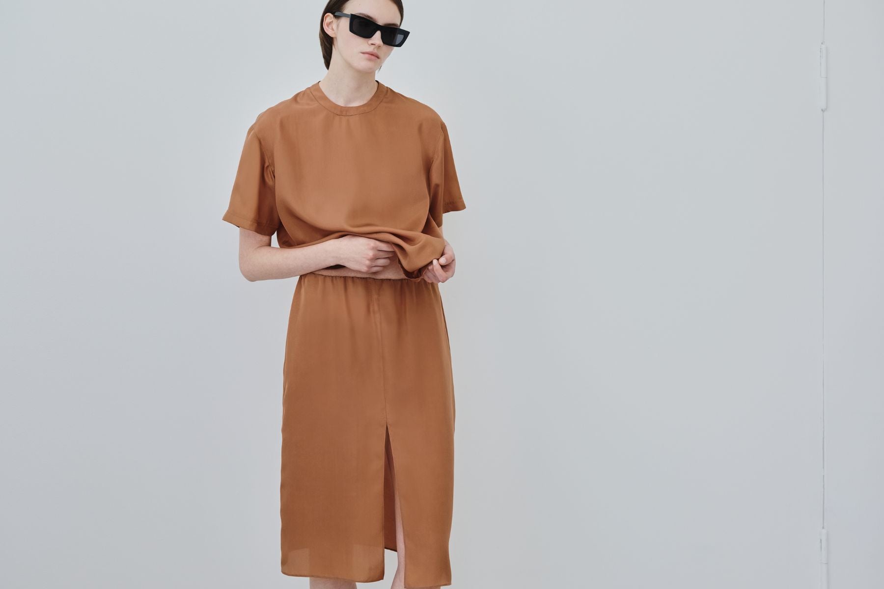 Model wearing organic silk co-ord set in rust, crafted in Italy by HERTH