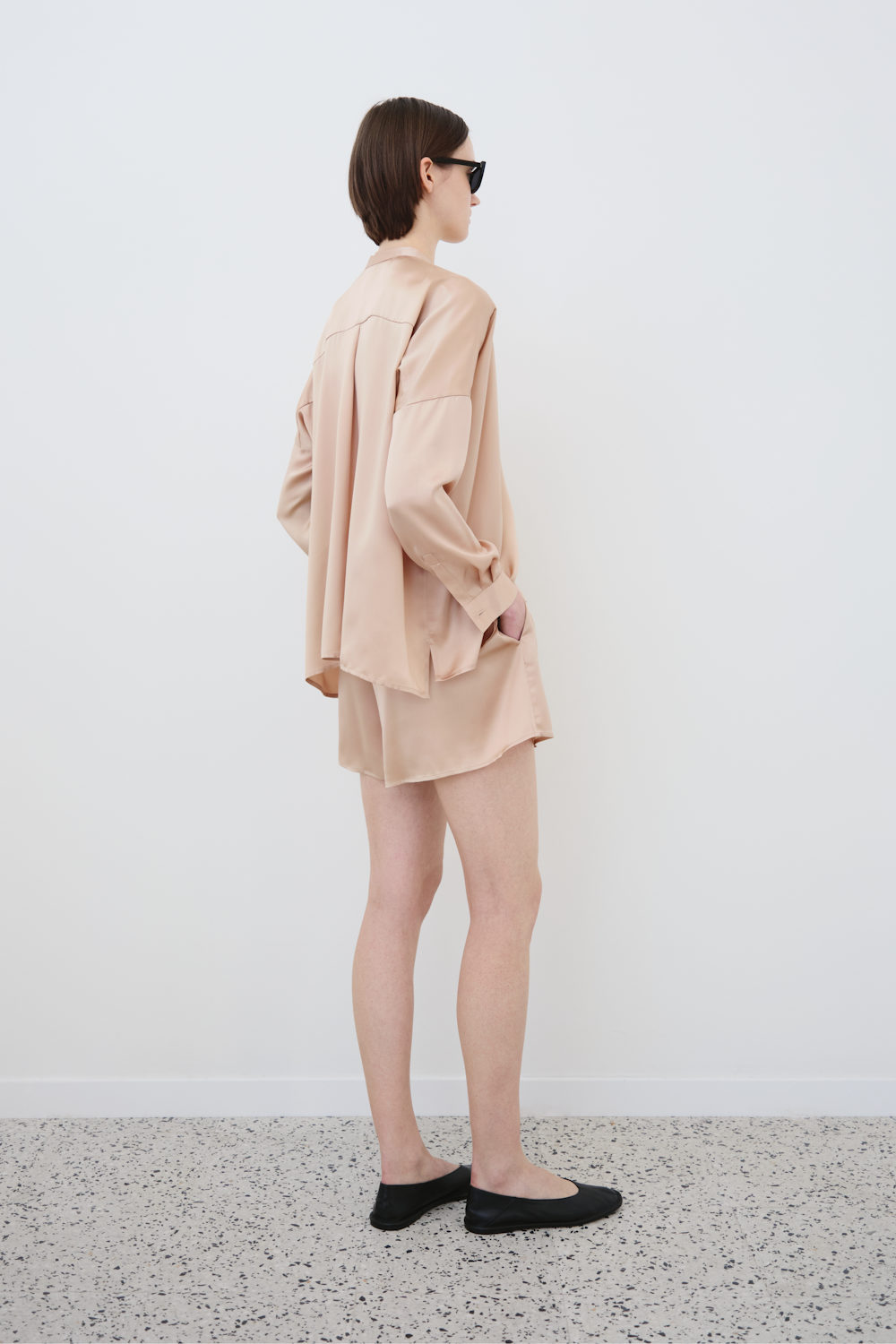 Model wearing minimal organic silk Tess shirt and Hani shorts womenswear set, back view, sustainable fashion by HERTH