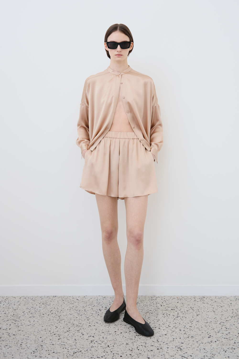 Model wearing minimal organic silk Tess shirt and Hani shorts womenswear set, front view, sustainable clothing by HERTH