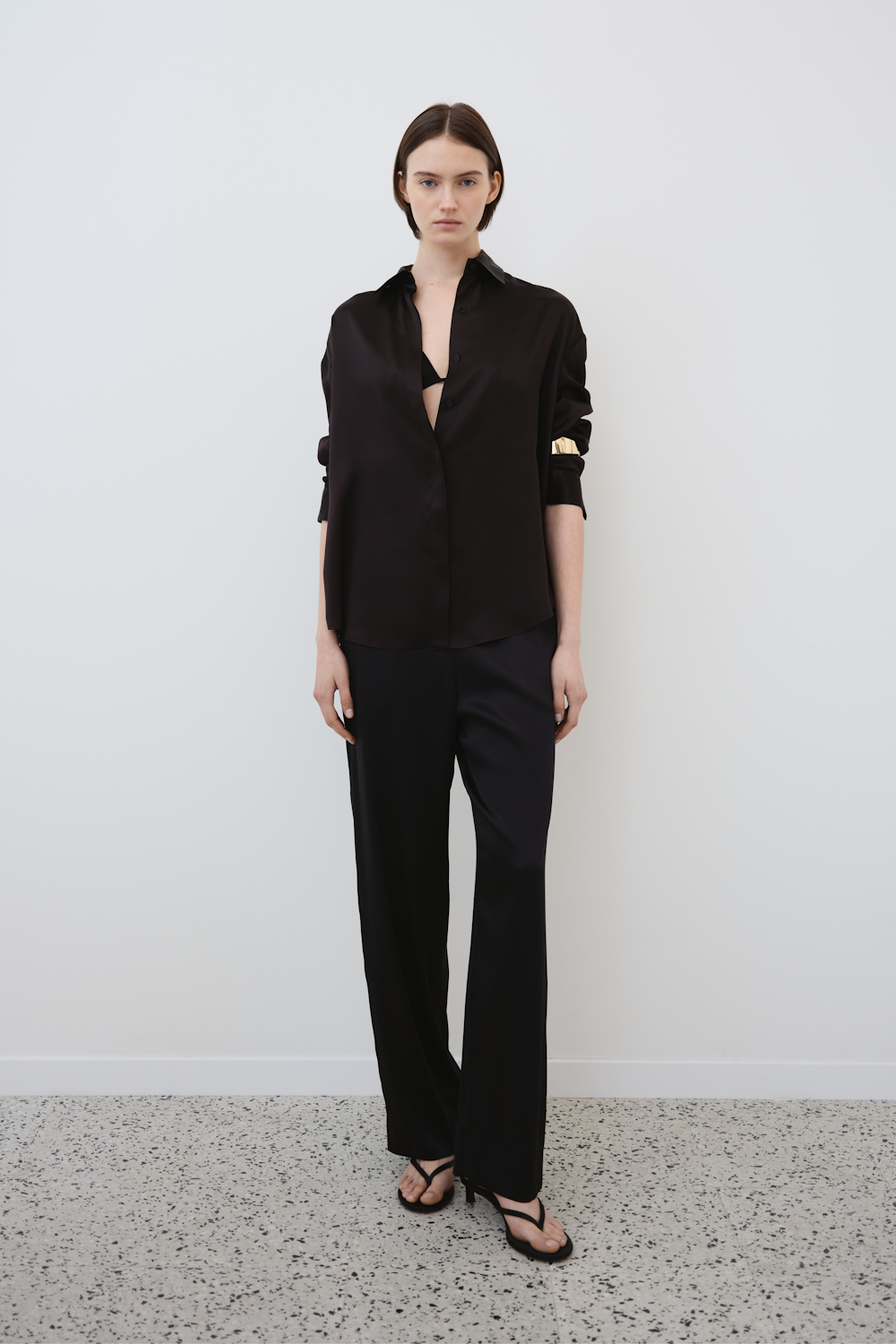 Model wearing HERTH’s black silk Tilde shirt and Zeno trousers — front view of elegant sustainable womenswear outfit crafted from organic silk.