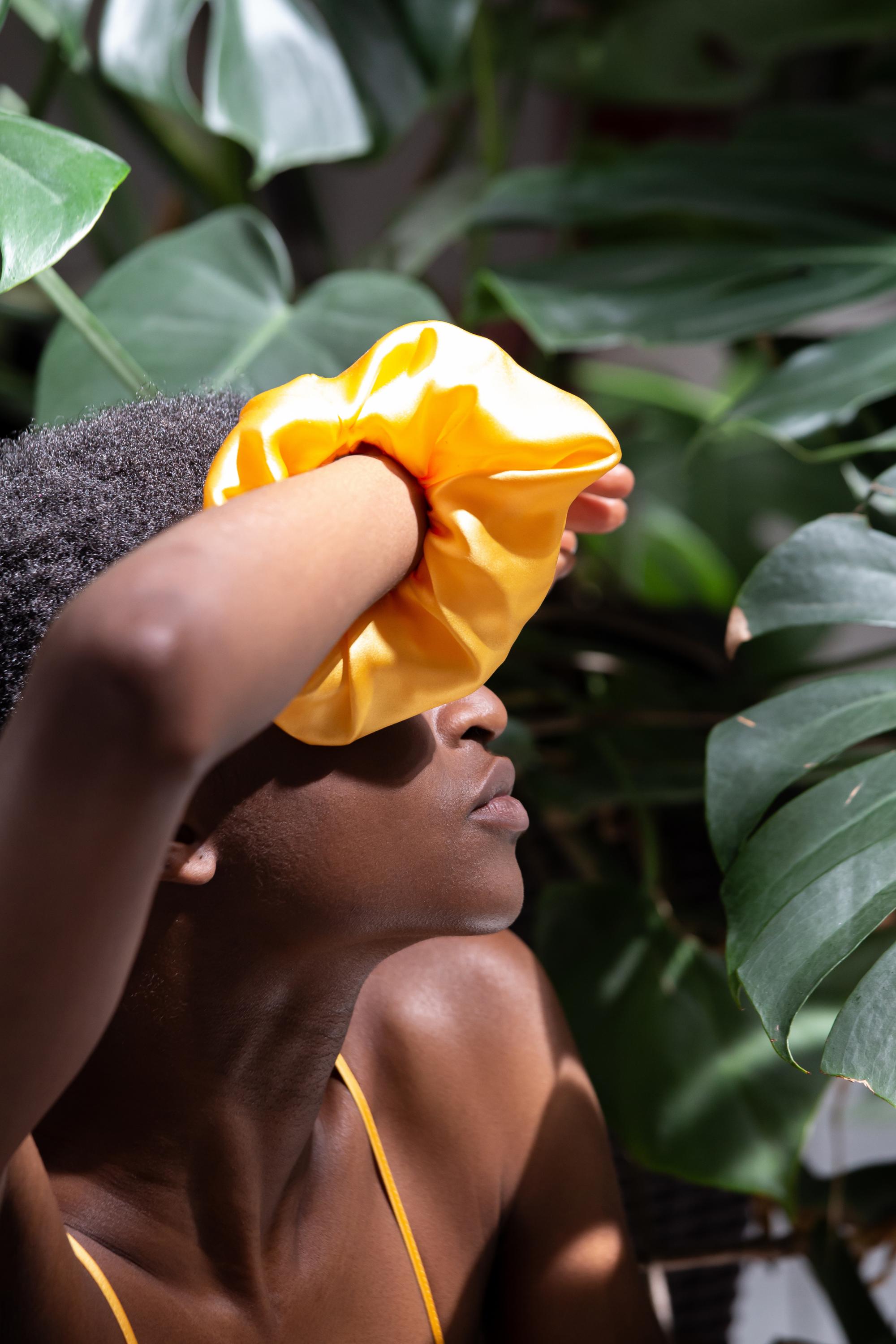 Organic silk scrunchie in mango color worn on the wrist, made in Italy