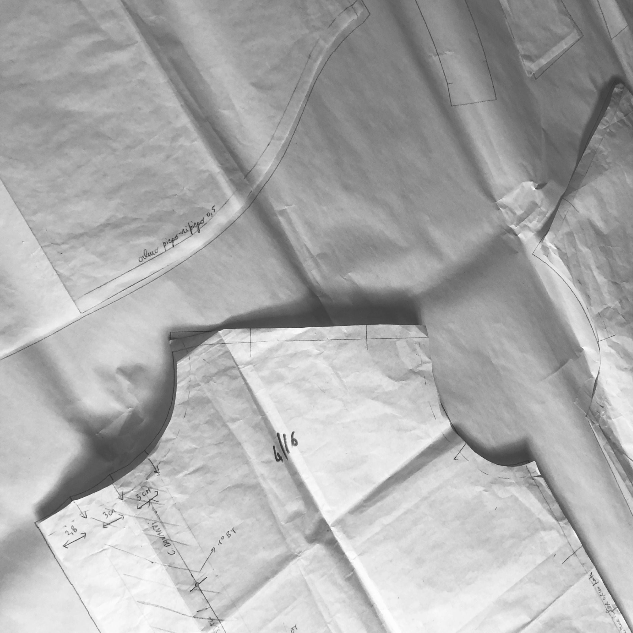 paper garment patterns used in silk design process, representing craftsmanship made in Italy