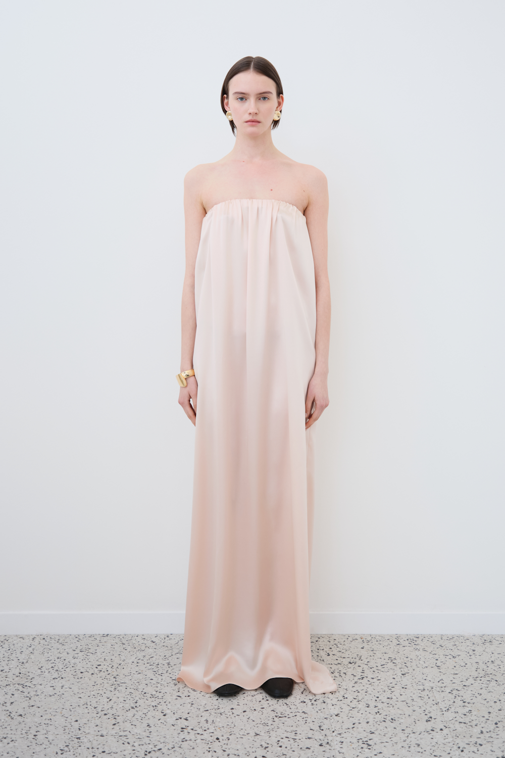 Front view of the HERTH Erin off-shoulder maxi slip dress in Whisper Pink — crafted from GOTS-certified organic silk, showcasing timeless and conscious womenswear elegance.