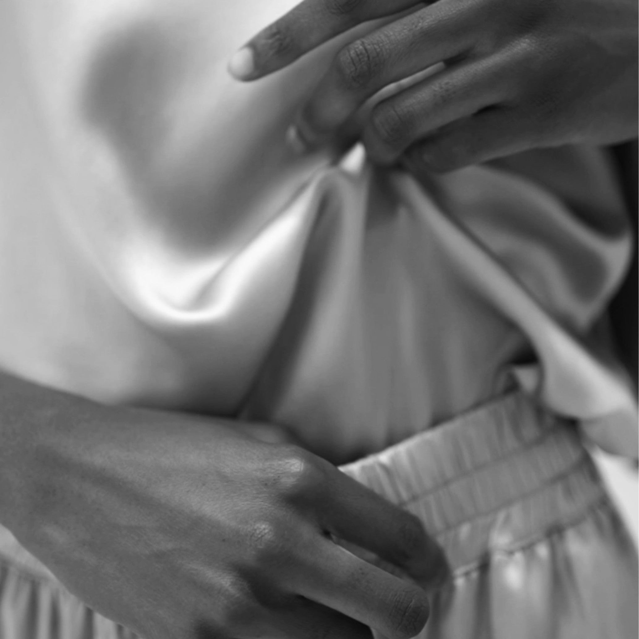 Close-up of organic silk fabric showing soft texture and fluid drape in HERTH garment