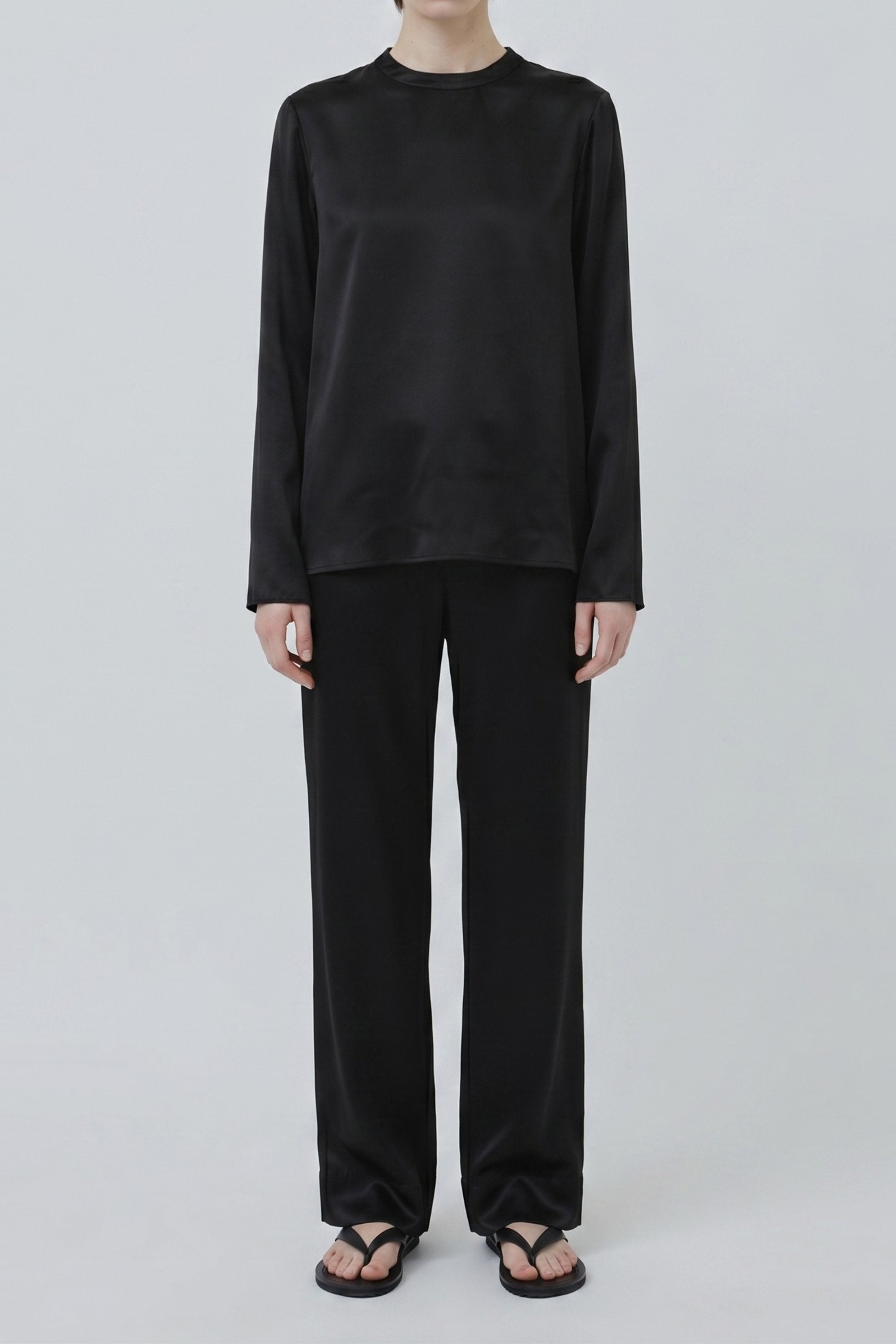 Organic silk long sleeve top in black worn untucked with wide-leg trousers, made in Italy, minimal studio look