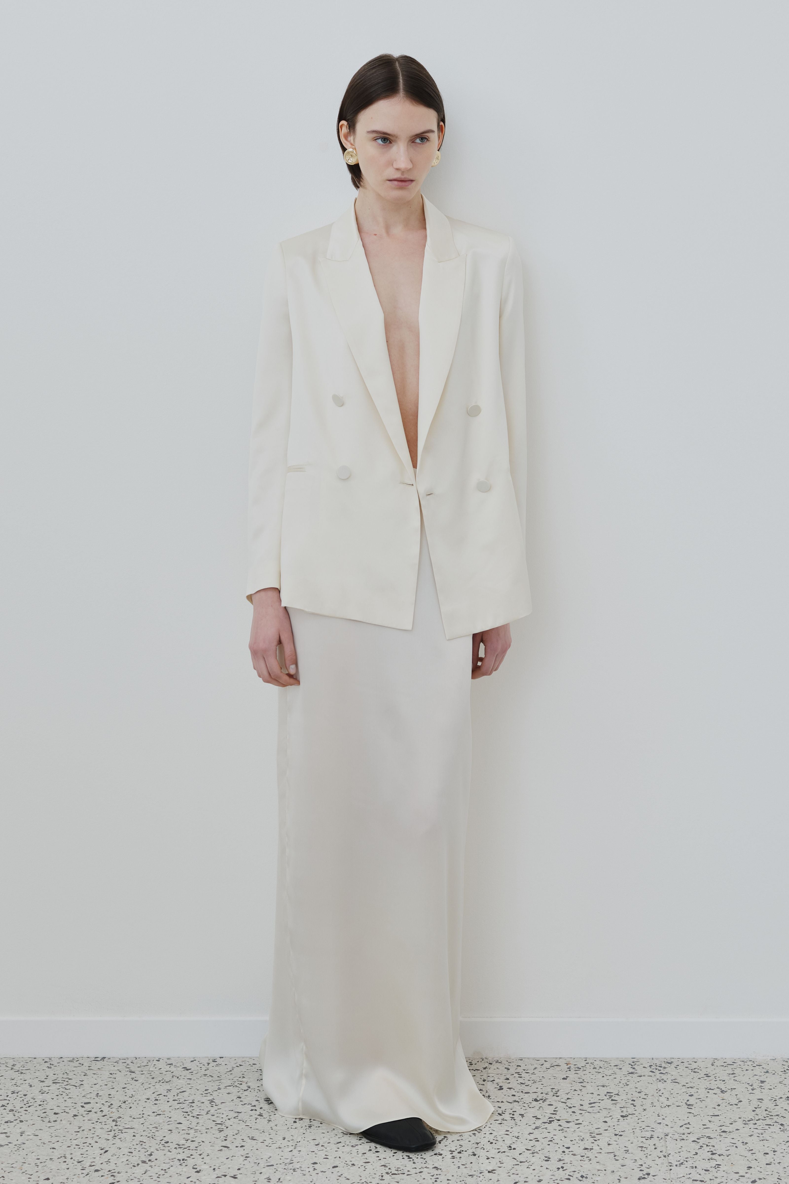 Model wearing the HERTH Uma organic silk blazer in Almond paired with the Nilde organic silk skirt, front view.