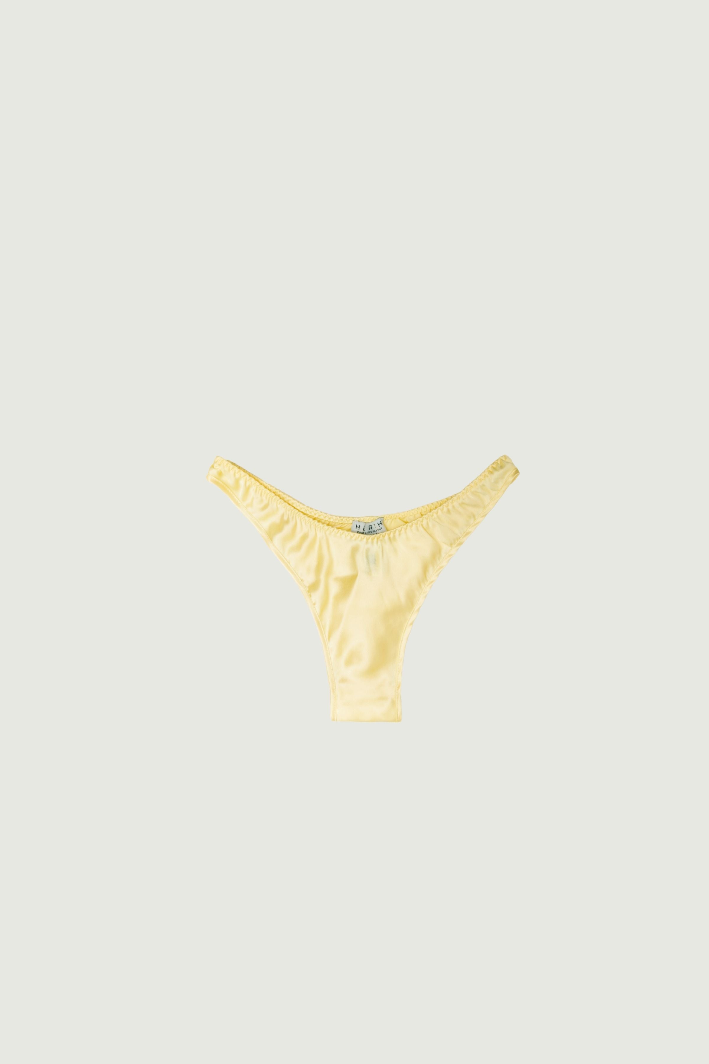 Butter yellow silk high-cut panty with minimal coverage, front view highlighting high-cut leg and soft pastel tone