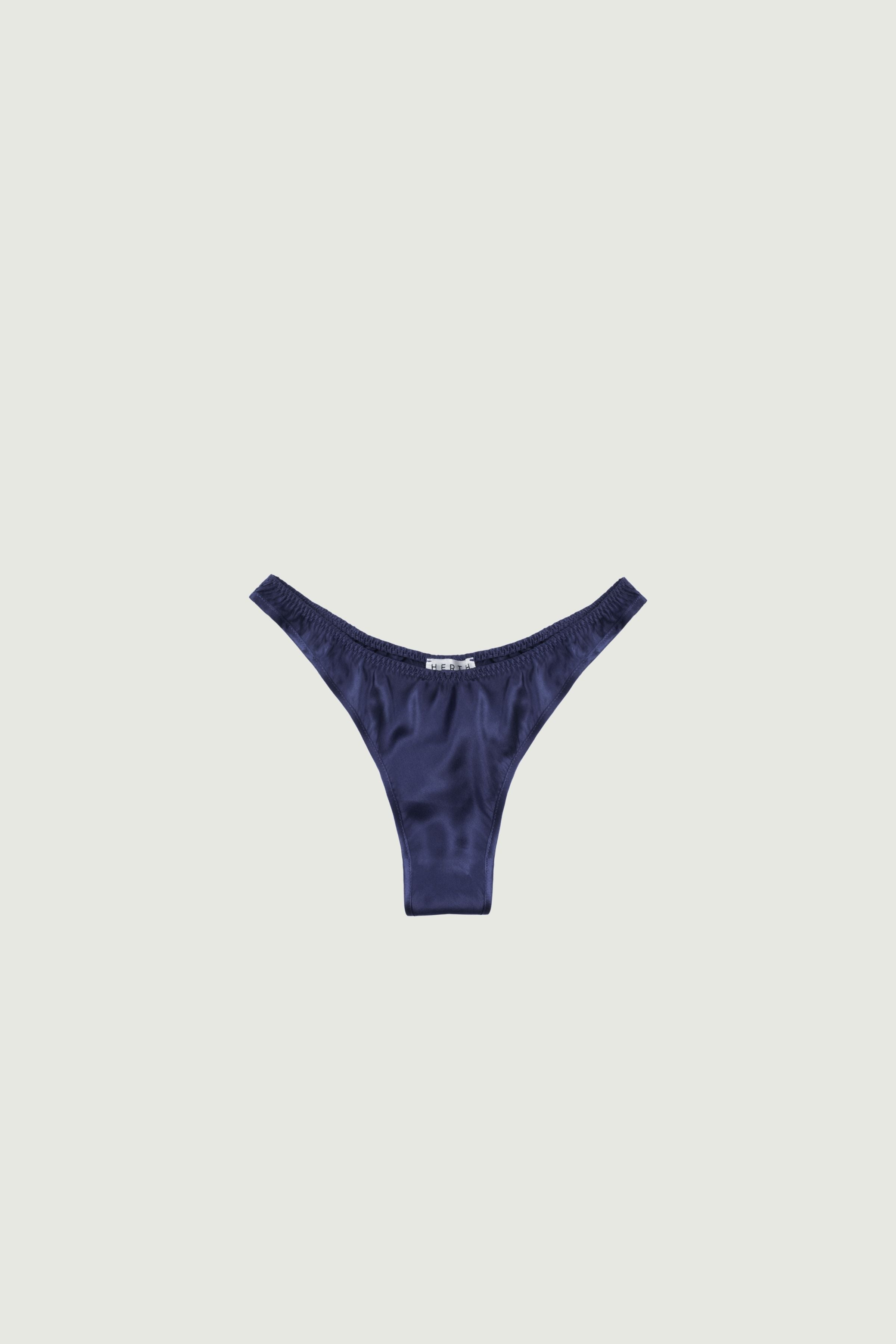Navy blue silk high-cut panty with minimal coverage, front view highlighting high-cut leg and deep refined tone