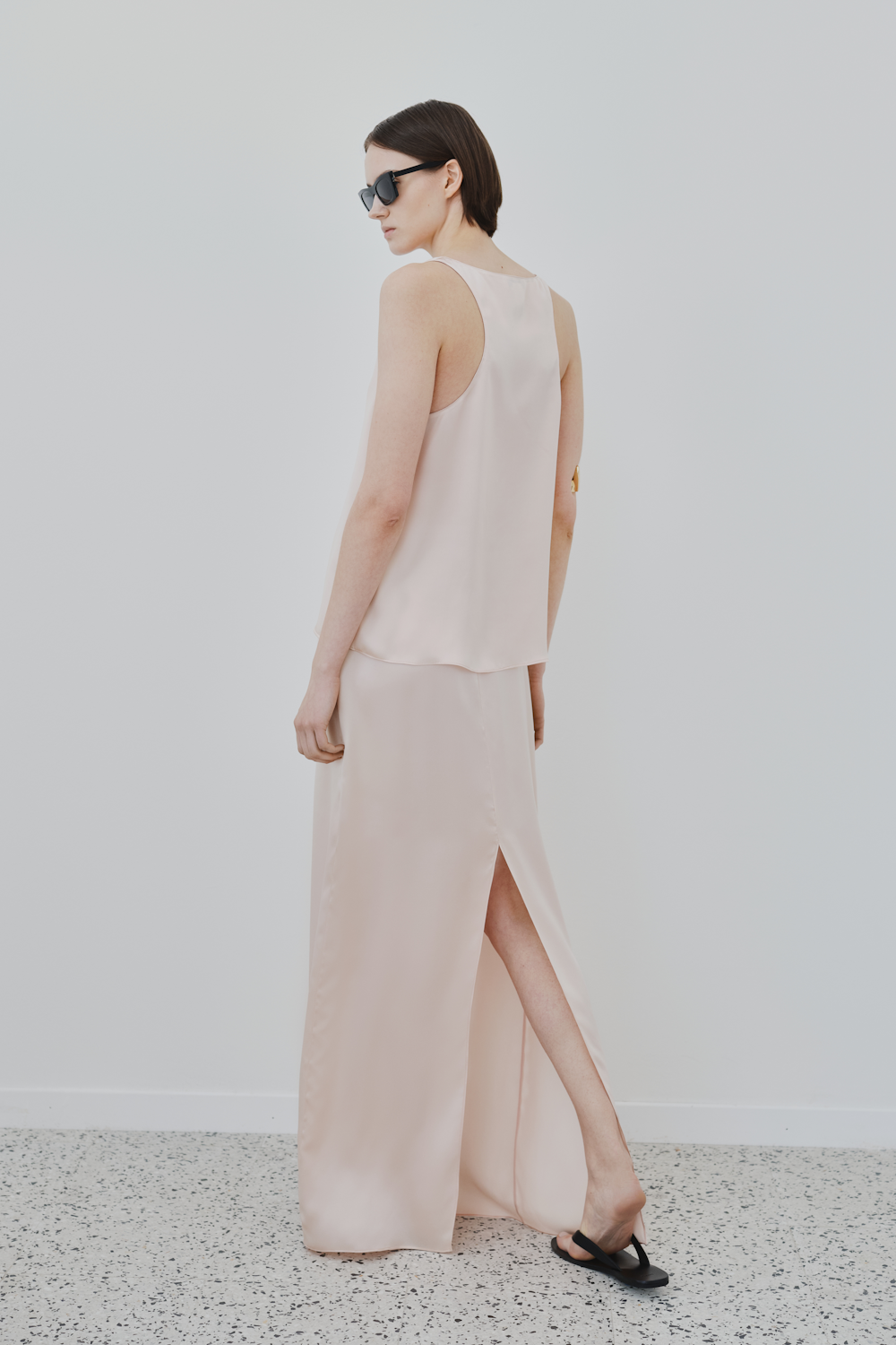 Back view of HERTH’s Nilde maxi skirt in Whisper Pink — crafted from GOTS-certified organic silk, featuring a side slit for effortless elegance in sustainable womenswear.