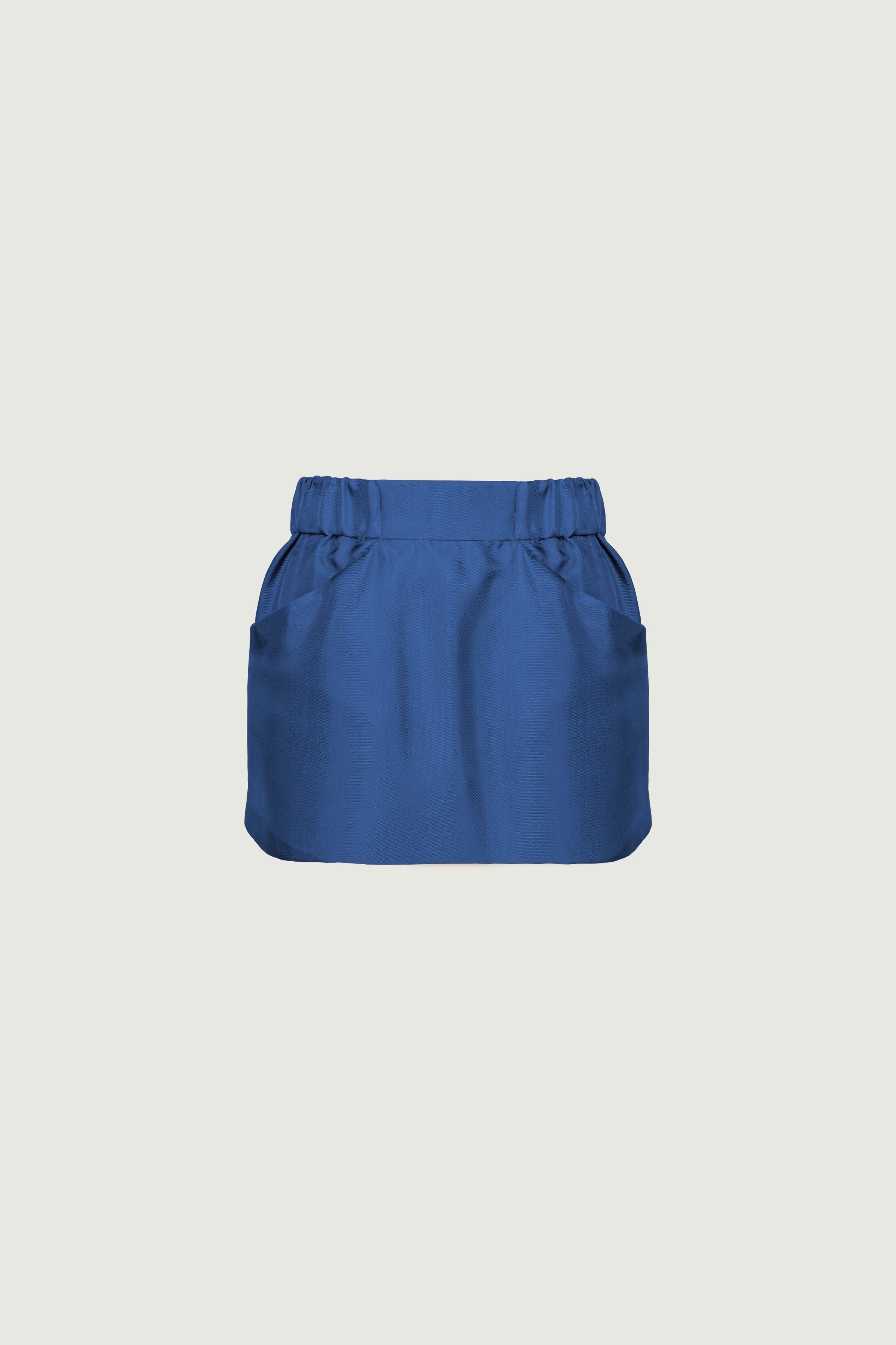 Denim blue organic silk twill mini skirt with front pockets and defined waistband, structured silhouette and smooth texture, front view