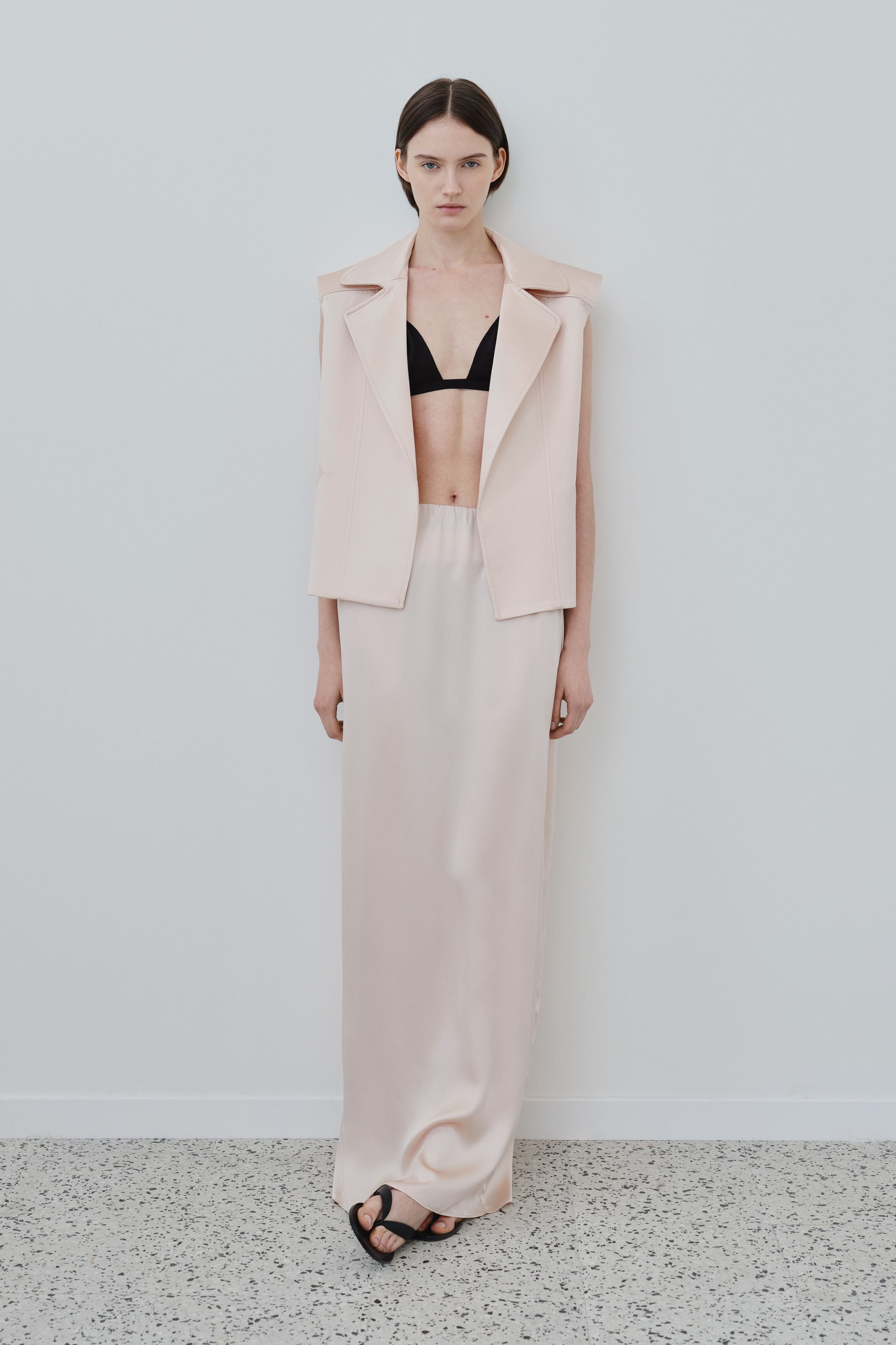 Model wearing ivory organic silk Nilde maxi skirt by HERTH, fluid silhouette with full-length drape, styled in a refined womenswear look, made in Italy
