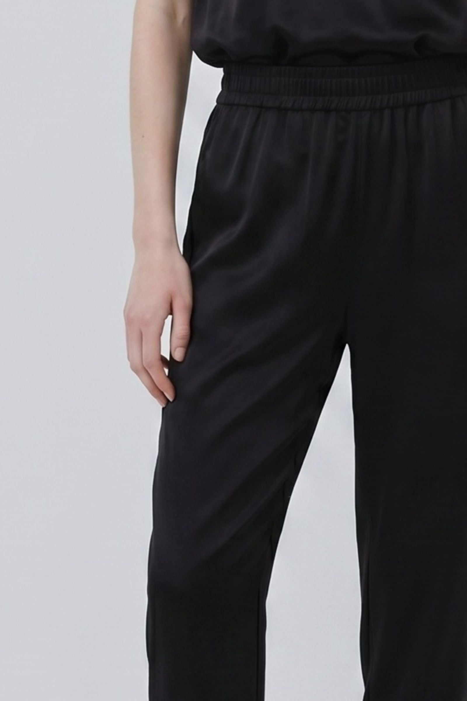 Black organic silk trousers with fluid drape and relaxed fit detail