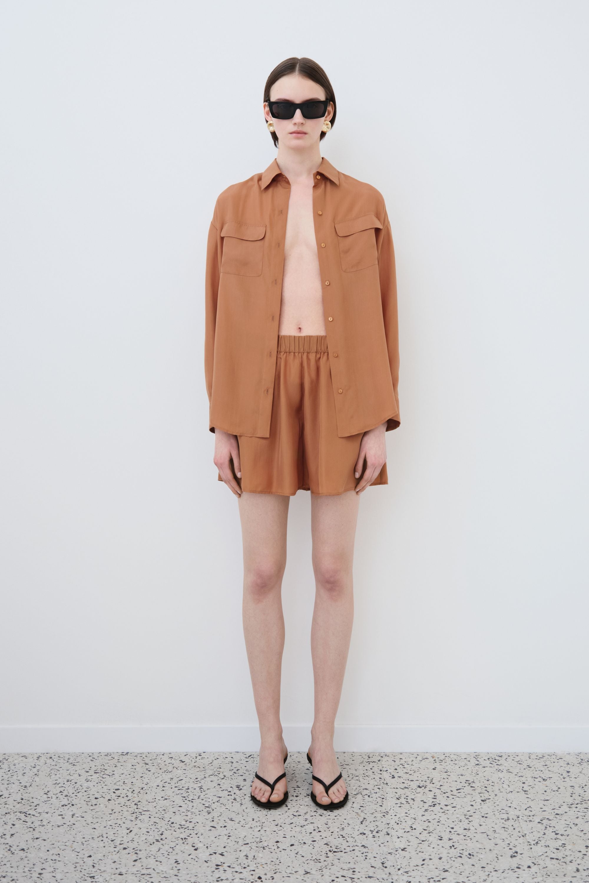 Model wearing organic habotai silk shirt and shorts set in earth tone, Tate shirt and Hani shorts made in Italy, front view