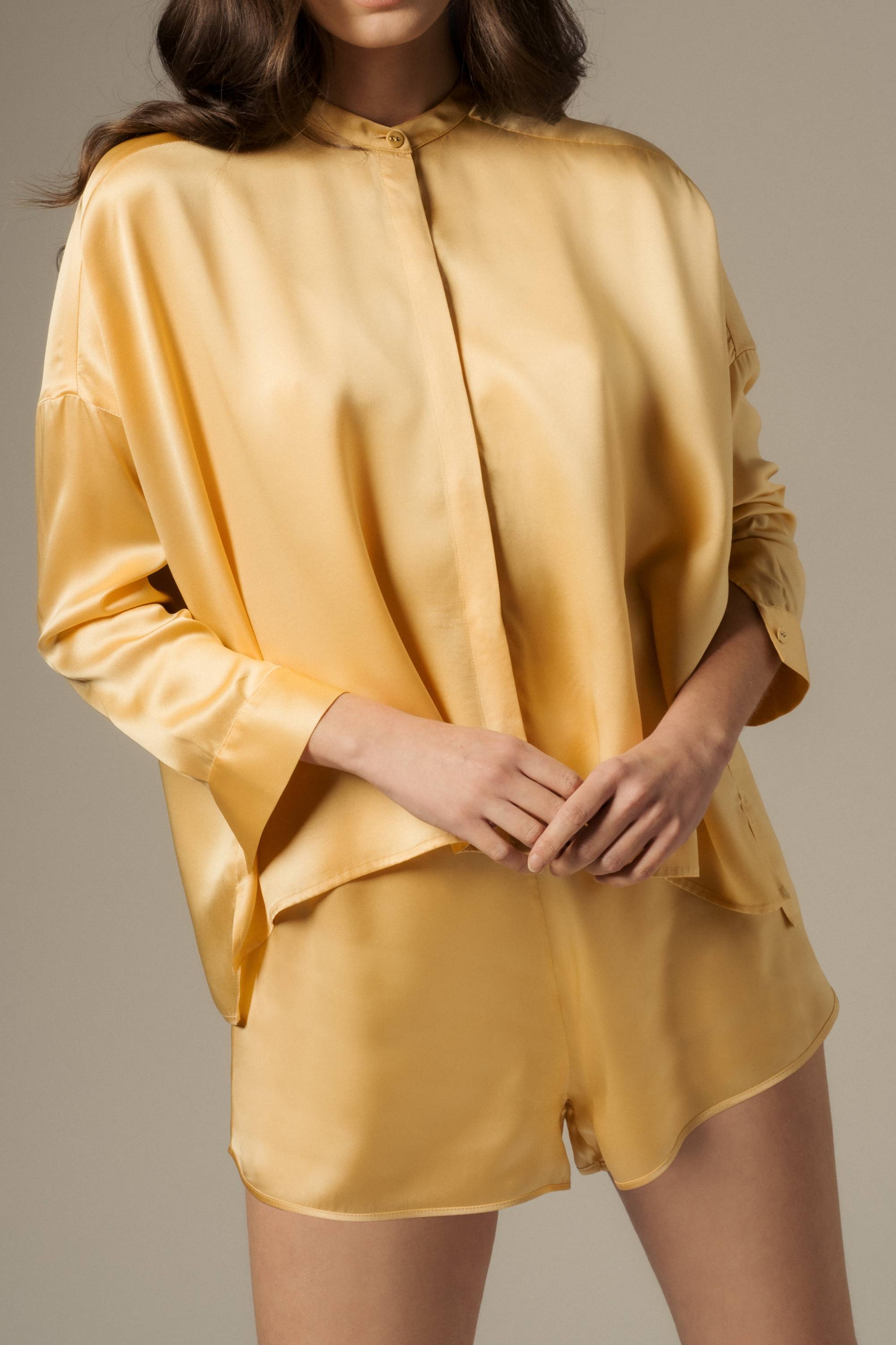 Model wearing organic silk shirt and shorts set in desert tone, Tess shirt and Yari shorts made in Italy, front view